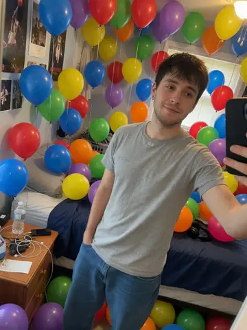 Exempel på Ballongöverdos: Hela rummet runt personen är fyllt från golv till tak med hundratals färgglada partyballonger.